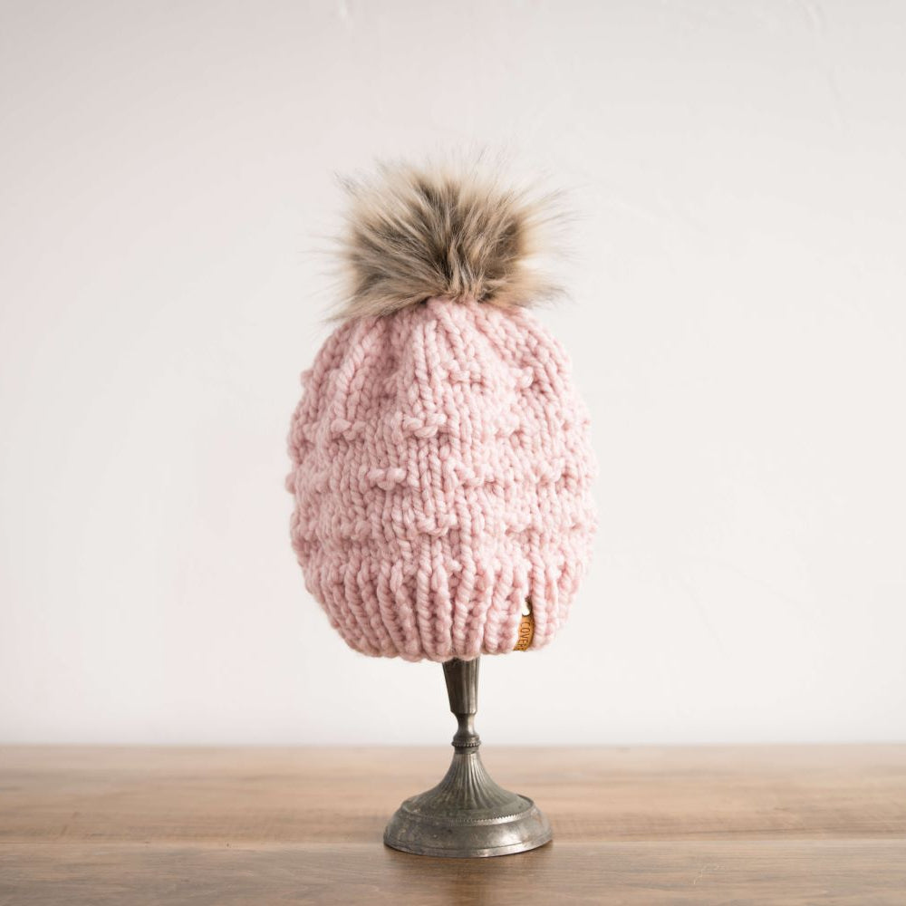 woman in blue knit hat with pom pom